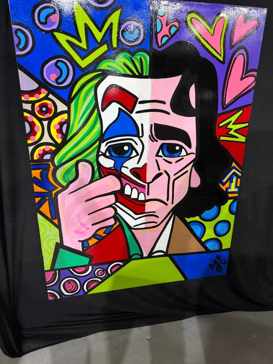 Mely G Art inquiry-first pop portrait showing a split-face figure with mask-like geometry, green hair detail, hearts, crown shapes, and saturated graphic pattern.